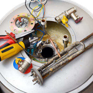 Broken water heater with tools and parts on top