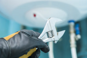 man holding wrenches to conduct water heater repair