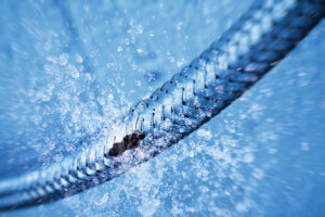 a gas and liquid leak emanating from a slit in a braided cord/wire